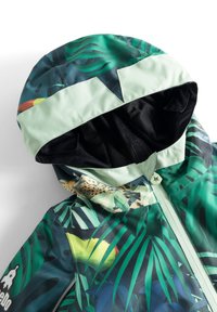 Giacca con cappuccio verde con motivo a foglie di giungla, dotata di chiusura con zip e rivestimento morbido a contrasto, realizzata in materiale resistente all'acqua.