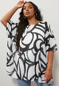 Top astratto in bianco e nero, con una vestibilità ampia, realizzato in tessuto leggero, con maniche corte e scollo rotondo.