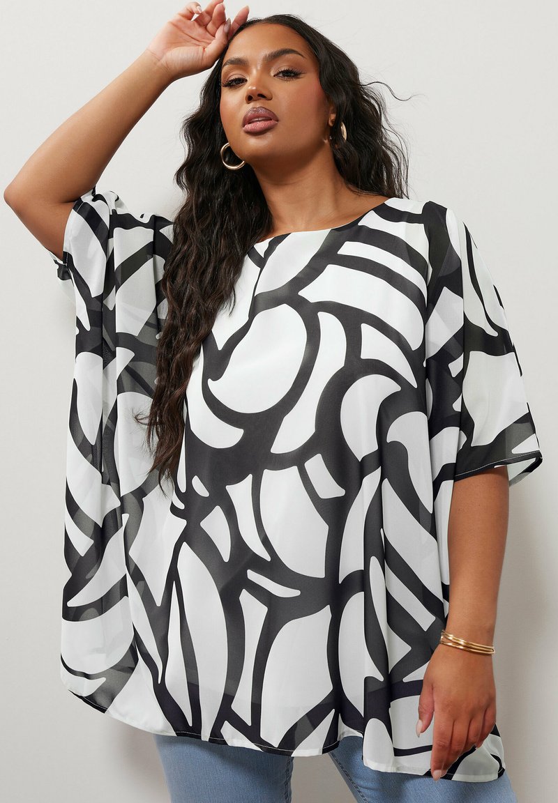 Top astratto in bianco e nero, con una vestibilità ampia, realizzato in tessuto leggero, con maniche corte e scollo rotondo.