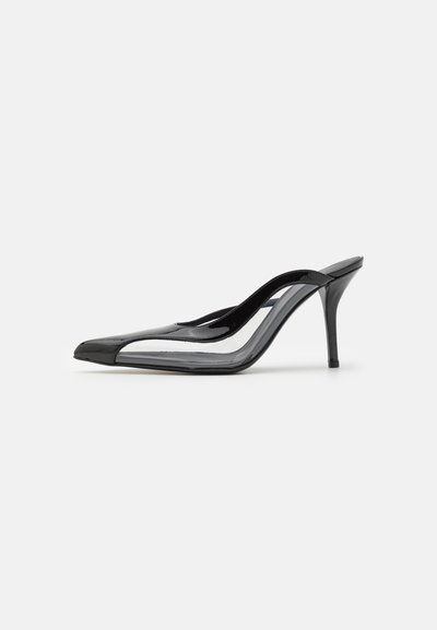 Black patent leather high-heeled slingback shoe with a pointed toe, clear accents, and a curved silhouette. Features a slender heel.