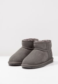 Graue Wildleder-Ankle-Boots mit einem weichen, flauschigen Futter, runder Spitze und einer niedrigen Gummisohle; detaillierte Nähte am oberen Rand.