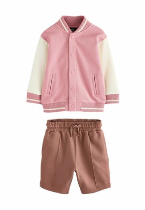 Giacca bomber rosa e panna con colletto e polsini a coste, abbinata a pantaloni corti marroni con coulisse. Tessuto morbido, design casual e tasche.
