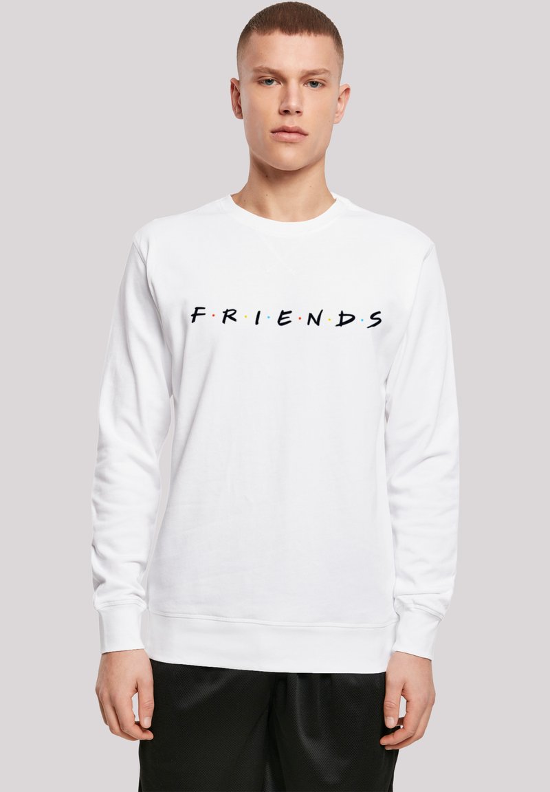 Felpa a maniche lunghe bianca con logo "FRIENDS" in nero e punti colorati. Tessuto morbido, polsini e orlo a coste. Modello che indossa pantaloni corti neri.