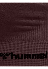 Bordeaux gebreide stof met een geribbelde textuur; opvallend zwart "hummel" logo. Soepel, ademend materiaal, ideaal voor sportkleding.
