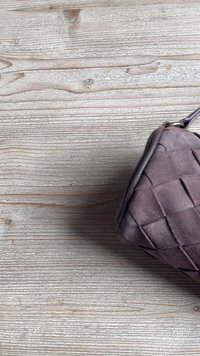 Rakennetun muodon ja irrotettavan olkahihnan omaava tekstiilellinen violetti mokkabag, jossa on kudottu kuvio ja hopeiset yksityiskohdat.