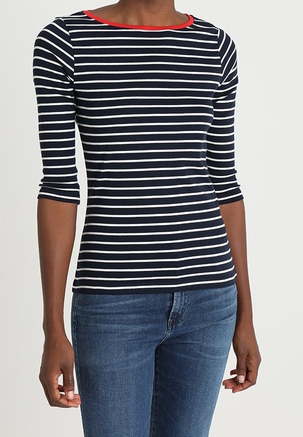Navy and white striped long-sleeve top with a red neckline, made from a soft material. Paired with blue denim jeans.