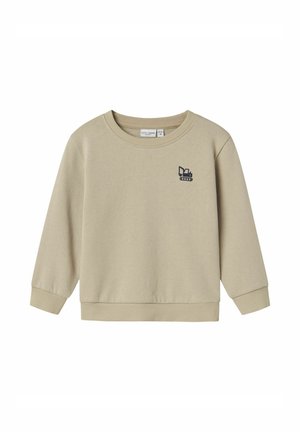 Sudadera beige con cuello redondo, puños y dobladillo acanalados. Presenta un pequeño diseño de logo en azul marino en la parte frontal. Textura de tela suave.