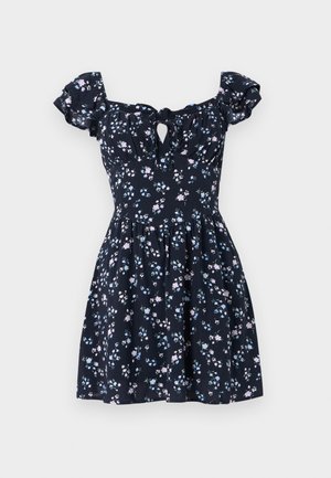 Merine lillelise kleit tumesinises kangas, lühikeste puffvarrukatega, rinnas on võtmeaugu detail ja laienev seelik, mis on kaunistatud roosa ja helesinise lilledega.