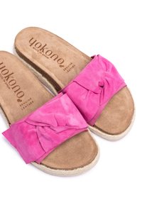 Sandales en suede rose avec un détail de nœud et une semelle intérieure en cuir brun. Semelle de style espadrille avec un bord en jute tissé.