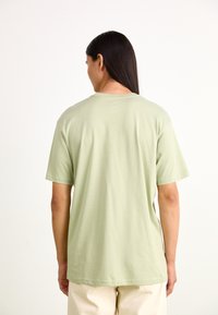Light green short-sleeve t-shirt with a round neck, made of soft cotton fabric, featuring a relaxed fit and subtle stitching details.