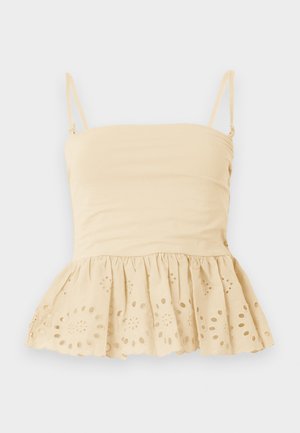 Top beige senza maniche con sottili spalline regolabili e orlo arricciato con motivi floreali ricamati e traforati.