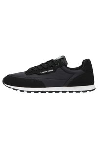 Sneaker sportivo nero con una combinazione di tomaia in suede opaco e testurizzato, suola in gomma bianca e lacci neri. Nome del marchio "Candice Cooper" in evidenza.