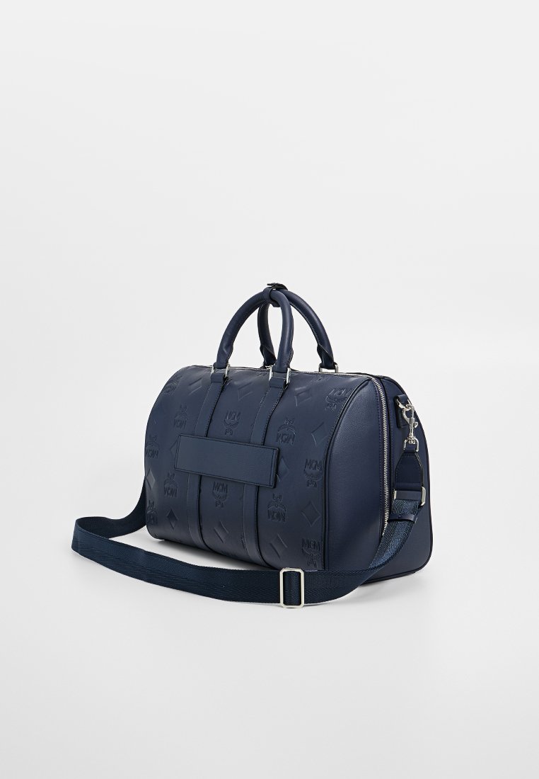 Navyblaue Leder-Duffle-Bag mit geprägtem Logo-Muster, doppelten Griffen und einem verstellbaren Riemen, ausgestattet mit einer Frontklappe und einem Reißverschluss.