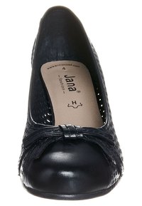 Svarta balettklackar med rund tå, strukturerad ovandel, liten rosettaccent och vadderad innersula. Yttersulan är slät och flexibel.