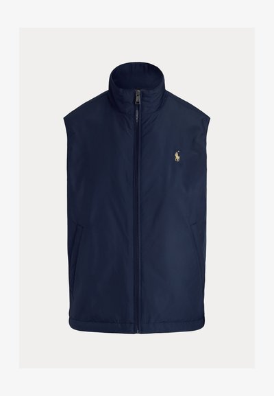 Mörkblå ärmlös väst i lätt tyg, med hög krage, frontdragkedja och liten broderad logga på vänster bröst.