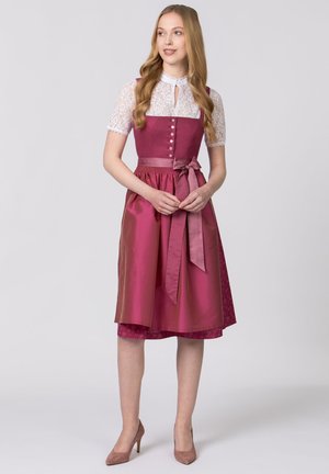 Long pink dress with a fitted bodice, lace sleeves, and a bow at the waist. Button details and a textured underlayer are notable.