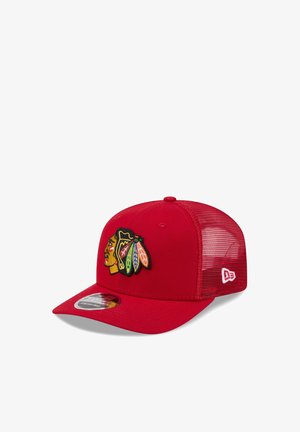 Red mesh baseball cap with multicolored Native American head logo embroidered on front and white brand logo on side.