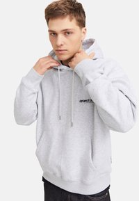Grau Baumwoll-Hoodie mit einer vorderen Kängurutasche, verstellbaren Kordeln und einem kleinen bedruckten Logo auf der Brust. Weicher, strukturierter Stoff.