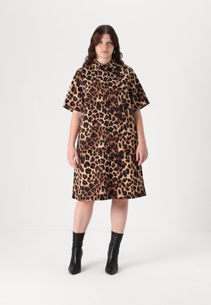Luipaardprint jurk in beige en bruine tinten, korte mouwen, met kraag, losvallend model, tot halverwege de dijen, gecombineerd met zwarte enkelboots.