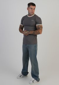 Halli lühikeste varrukatega t-särk halli värvi, kontrastsete heledate ääredetailidega, kaasas helesinised teksad ja valged nohikkingad hallide aktsentidega.