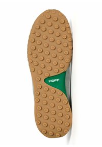Semelle d'une sneaker avec un fond en caoutchouc brun texturé, présentant des grips circulaires et un logo HOFF vert dans une section découpée.