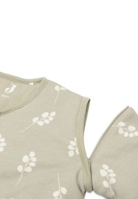 Vêtement vert clair à manches courtes en tissu doux, avec des motifs de feuilles blanches et un col rond avec une fermeture à pression.