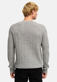 Szary sweter z dzianiny o splocie warkoczowym, z okrągłym dekoltem i długimi rękawami, z wyraźnym wzorem oraz ściągaczami na rękawach i marginesie.