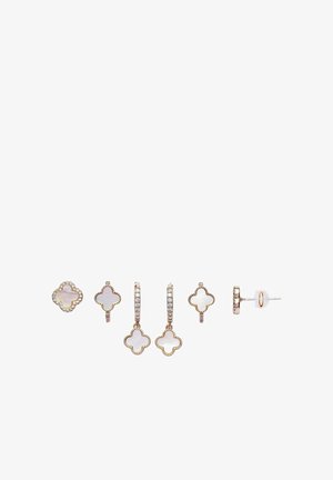 Six boucles d'oreilles en or et nacre en forme de trèfle, comprenant des clous et des petits anneaux avec des accents en cristal, disposées en rangée sur fond blanc.