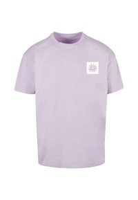 Lilla bomulds t-shirt med rund hals og korte ærmer. Har et lille hvidt firkantet logo med et blomsterdesign på venstre bryst.