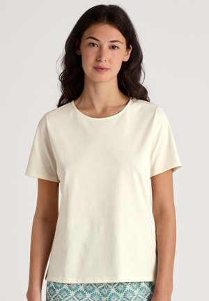 Helle beige Kurzarm-T-Shirt aus weicher Baumwolle. Verfügt über einen runden Ausschnitt und einen lockeren Schnitt. Glatte Textur ohne sichtbare Muster.