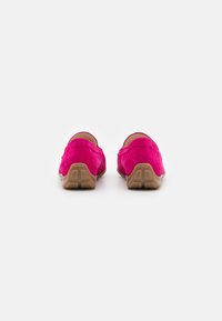 Růžové semišové slip-on boty s kulatými patami a světlou hnědou gumovou podrážkou, které mají jednoduchý, hladký design bez ozdob.