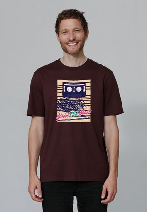 T-shirt en coton marron arborant un graphique d'une cassette vintage avec le texte "Good Old Mess" en lettres colorées.