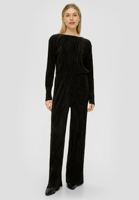 Zwarte plissé jumpsuit met lange mouwen, bootnek en een getailleerde taille. Gemaakt van textuurstof, met wijde broekspijpen en een gladde afwerking.