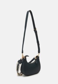 Kompakt mörkgrön läderhandväska med guldfärgad detalj, justerbar rem och en slät yta. Har dragkedjeslutning och en extra mindre rem.