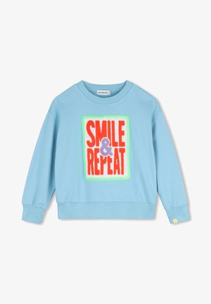 Lyseblå sweatshirt med lange ærmer med ribbede manchetter og kant, med et farverigt patch med teksten "SMILE & REPEAT" på fronten.