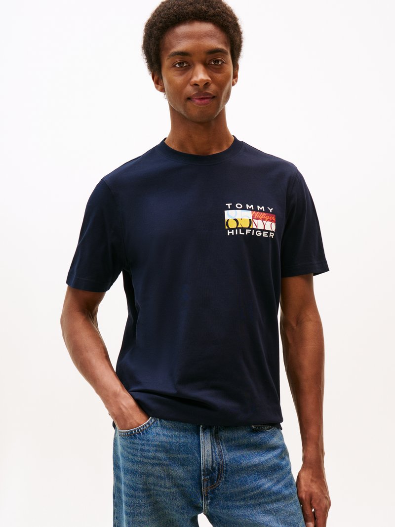 T-shirt en coton bleu marine avec le logo "TOMMY HILFIGER" en lettres multicolores sur la poitrine gauche. Coupe décontractée avec des manches courtes.