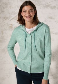 Ljus teal-färgad cardigan med huva, knappstängning och långa ärmar. Gjord av mjukt material med kontrasterande ribbade kanter och dragsko.