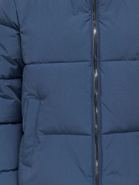 Mėlyna pūkinė striukė su glotnia, tekstūruota apdaila, su siuvinėtomis dalimis, užtrauktuku ir šoniniu kišeniu.