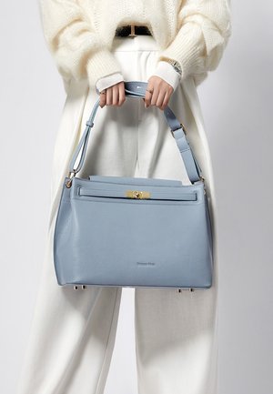 Bolso de mano de cuero azul claro con forma estructurada, detalles en hardware dorado y una correa desmontable. Textura suave y cierre superior con cremallera.