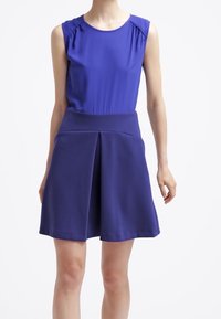 Bezramínková fialová šaty s přiléhavým vrškem a rozšířenou sukní. Hladká tkanina s jemným leskem a sklady v pase pro přidaný objem.