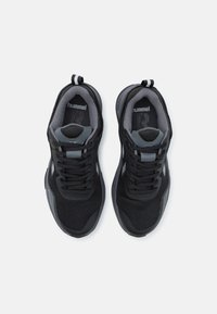 Zapatillas deportivas negras con parte superior de malla y sintético. Acentos grises en los lados y el talón, con un sistema de cordones y una lengüeta para facilitar el calzado.