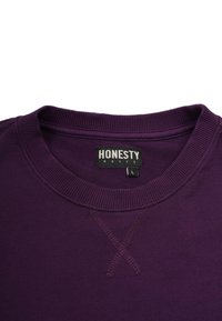 Lila Crewneck-Sweatshirt mit geripptem Kragen, sichtbaren X-förmigen Nähten unterhalb des Halsauschnitts und dem Markenlabel "Honesty Rules" im Kragen.