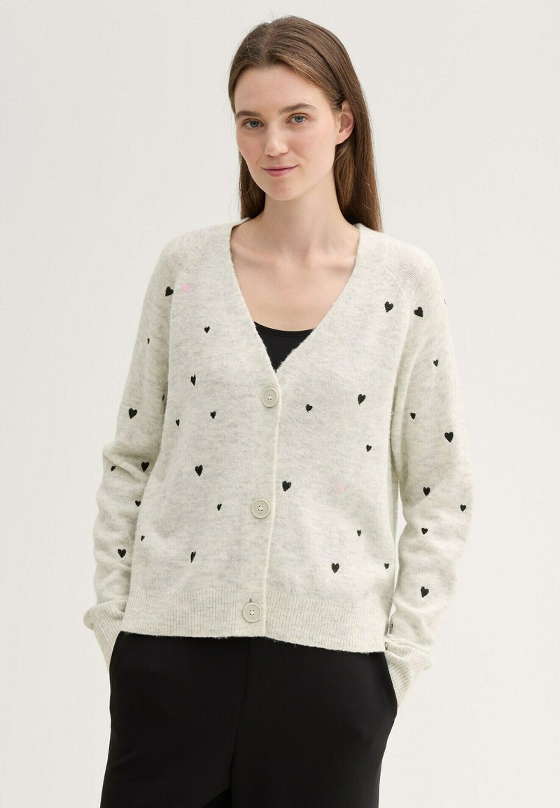 Jasnoszary kardigan z miękkiego materiału, ozdobiony rozproszonym wzorem czarnych i różowych serc, zapinany na guziki, z prążkowanymi mankietami i obszyciem dolnym.