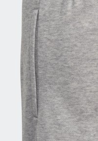 Detalle en primer plano de una tela de punto gris con un bolsillo vertical a lo largo de la costura.