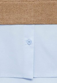 Hellblaues Hemd mit einem gerippten beigen Kragen, ausgestattet mit einer Knopfverschlüsse und glatter Stoffstruktur. Einfaches Design mit klaren Linien.
