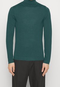 Türkiser Rollkragenpullover aus Strickstoff, mit langen Ärmeln und enger Passform, mit einem nahtlosen Kragen und Rippbündchen.