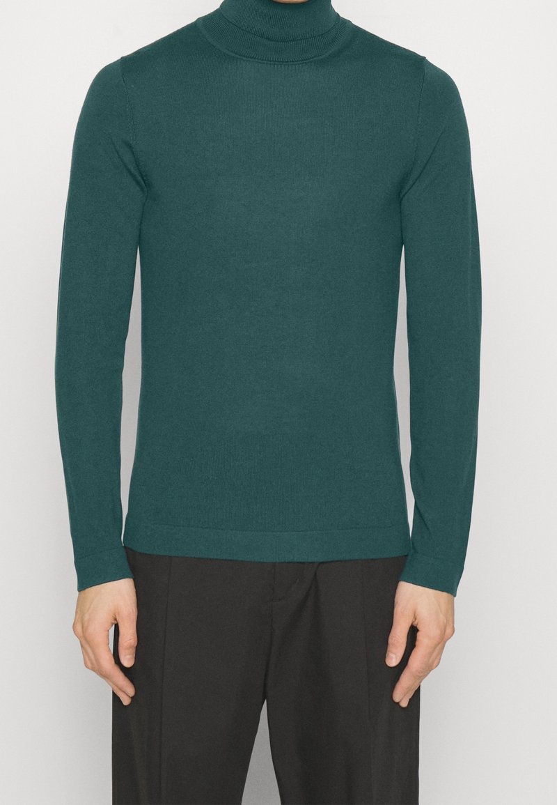 Türkiser Rollkragenpullover aus Strickstoff, mit langen Ärmeln und enger Passform, mit einem nahtlosen Kragen und Rippbündchen.