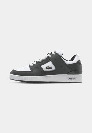 Lacoste-sko med en hvit læroverdel med grå detaljer, snørelukking, teksturert materiale og en logo på siden.