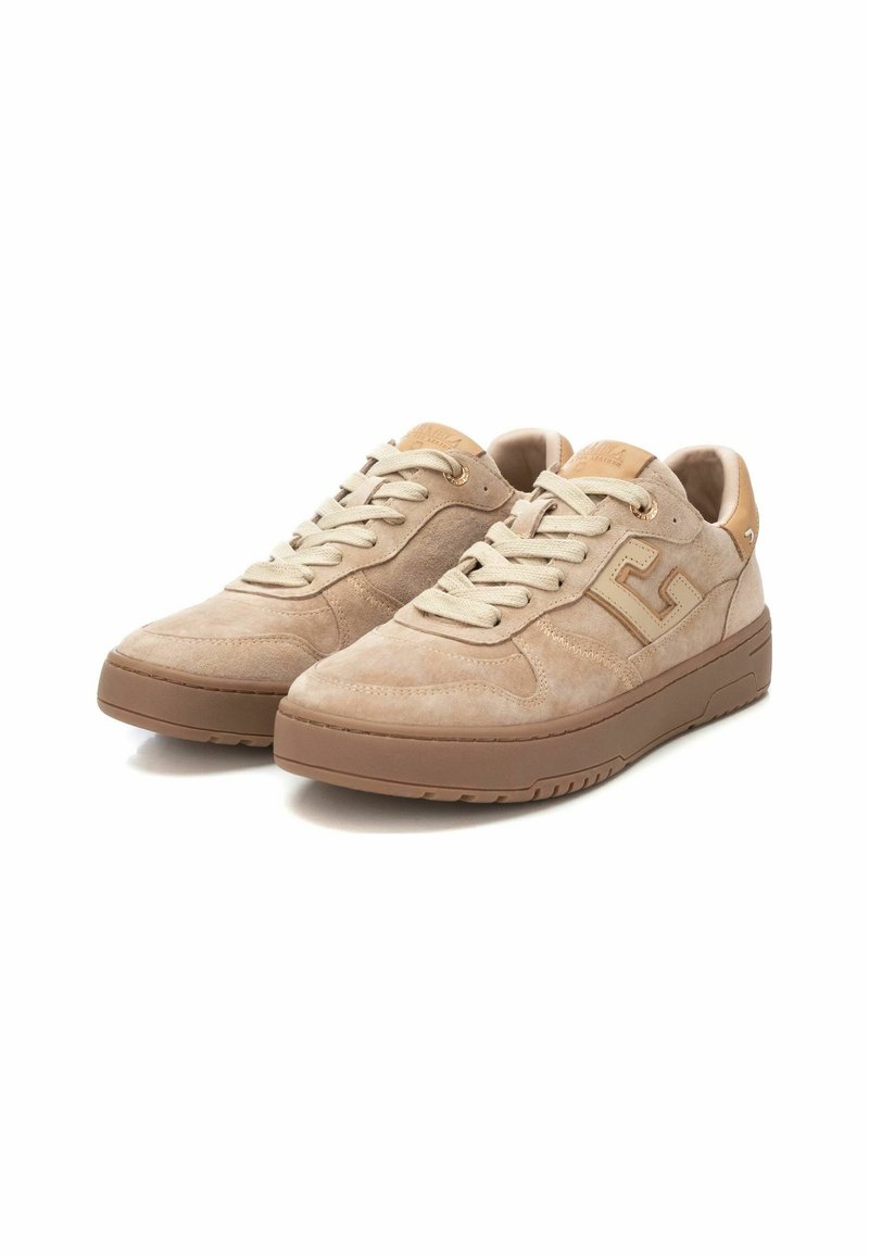 Baskets en daim beige avec une finition texturée, lacets plats et semelle en caoutchouc. Présente un accent de logo sur le côté et un col rembourré.