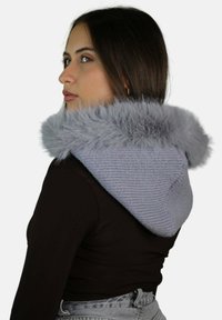 Cappuccio grigio in maglia con rifinitura in pelliccia sintetica, che mostra un tessuto testurizzato e una superficie liscia a contrasto. Presenta una forma morbida e una vestibilità aderente.